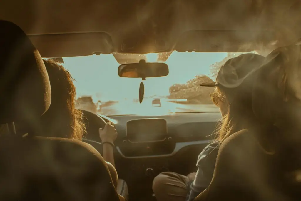 Two women driving on a sunny day showcasing road trip adventure in summer.